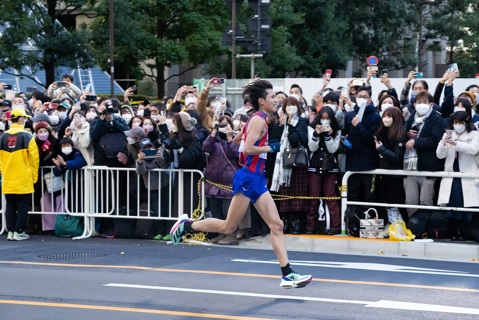Runner passing crowds behind barriers on the Otemachi course of the 2023 Hakone Ekiden