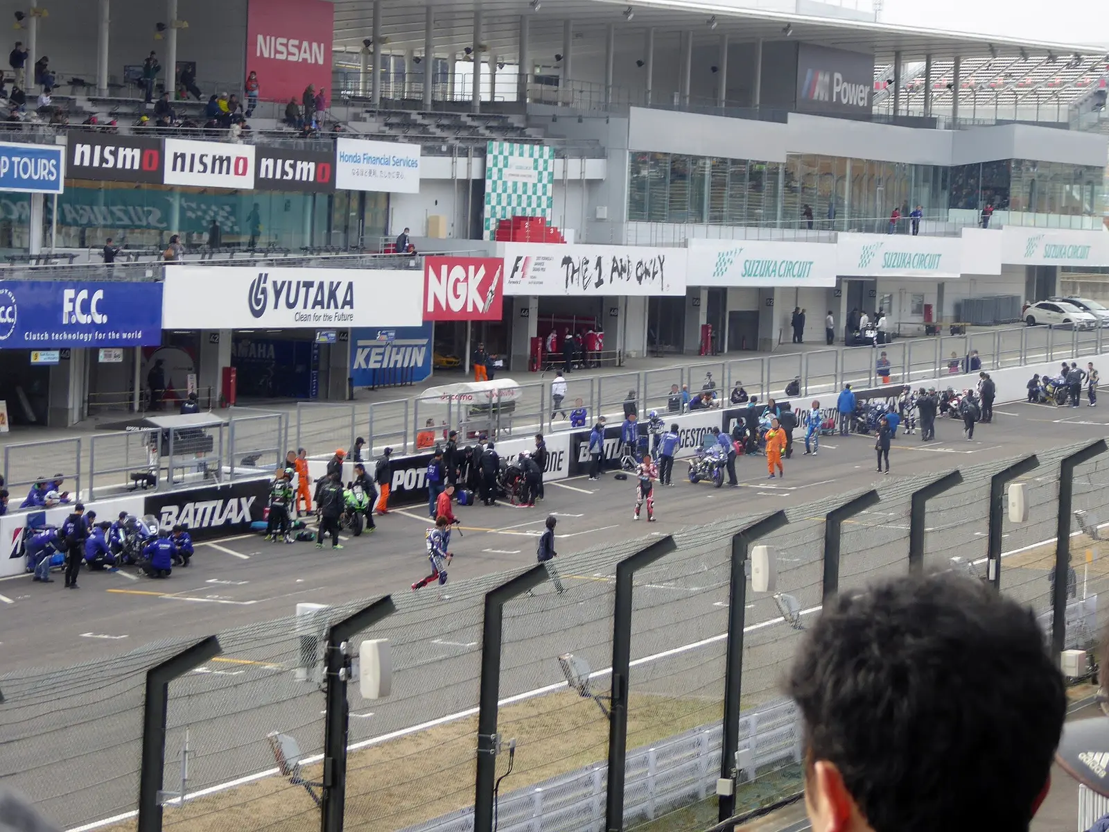 Pit lane and grandstand at Suzuka Circuit during a Le Mans-style start of historic machines at the Suzuka 8 Hours