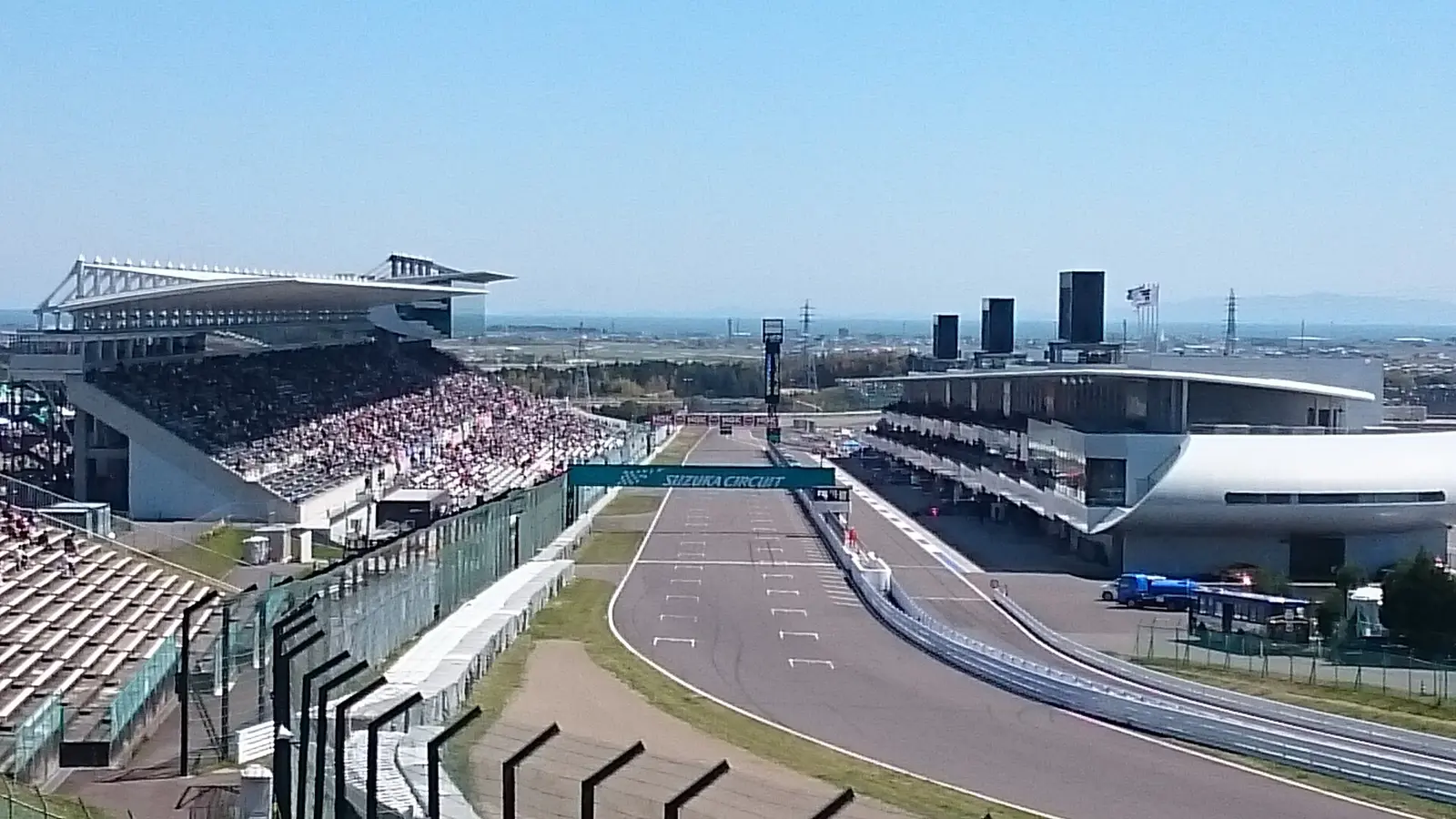 Main straight of Suzuka Circuit with grandstands and pit buildings