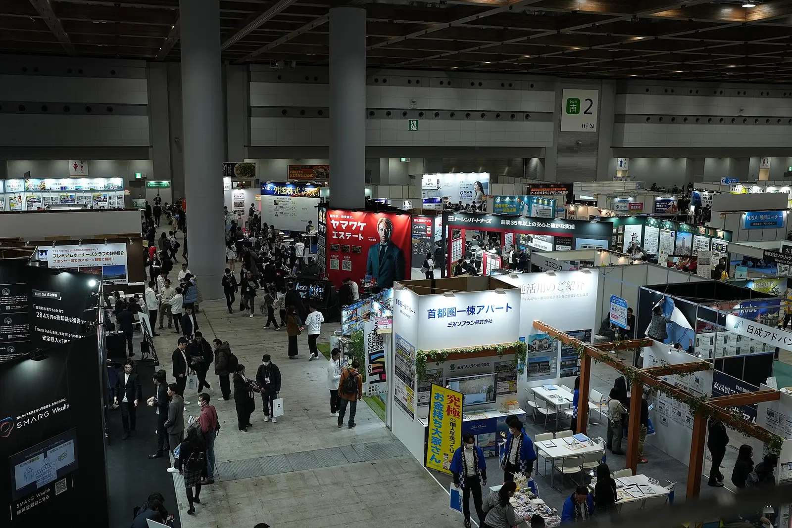 Visitors walking among exhibitor booths in an exhibition hall at Tokyo Big Sight