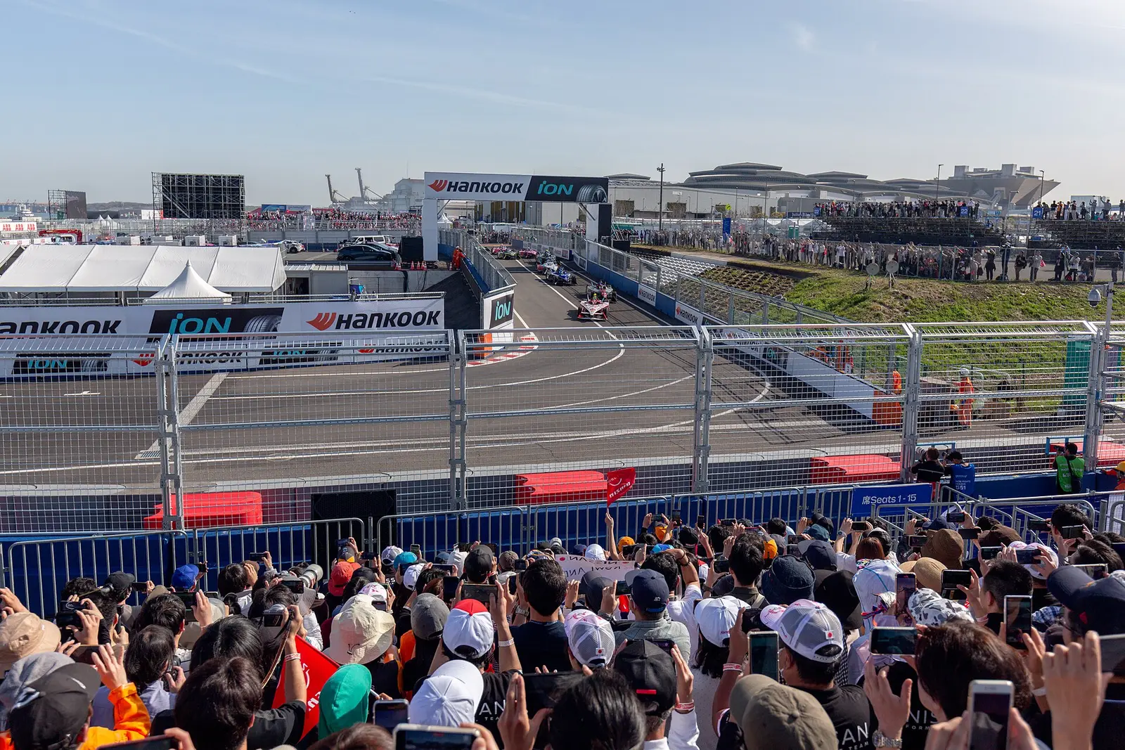 Crowd at the track fence watching the race start of the 2024 Tokyo E-Prix near Tokyo Big Sight